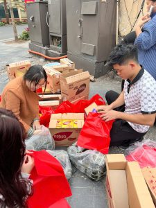 Các tình nguyện viên tất bật đóng gói bánh chưng và bánh kẹo vào túi quà đỏ gửi tặng bệnh nhân.