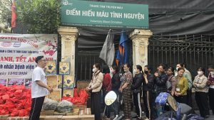 Người nhà và bệnh nhân tại Bệnh viện Việt Đức xếp hàng trật tự chờ nhận quà Tết từ Bánh Tuấn Nghĩa và các đơn vị.